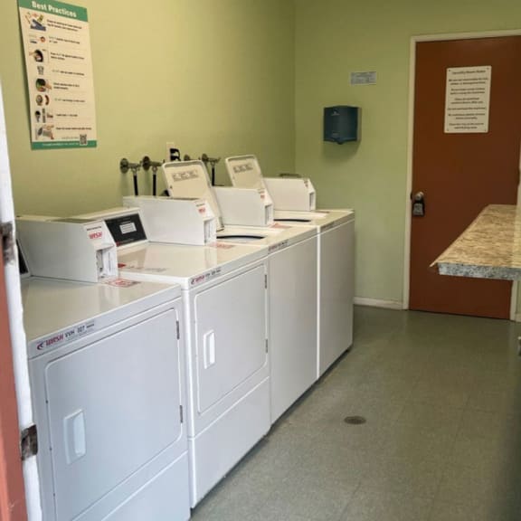 a row of washers and dryers in a room