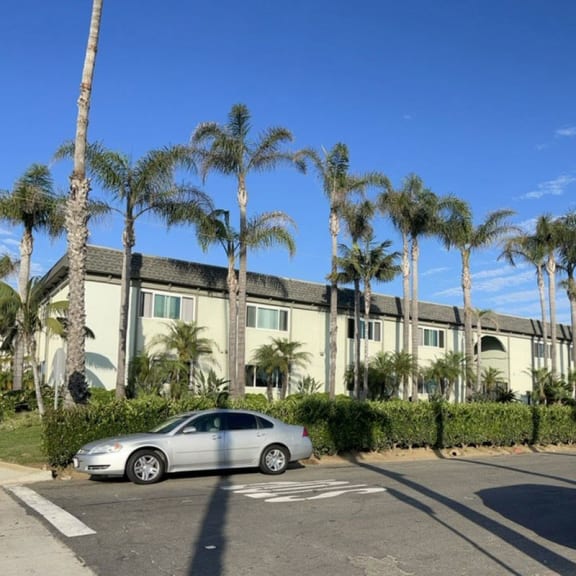 a car parked in a parking lot in front of a large building