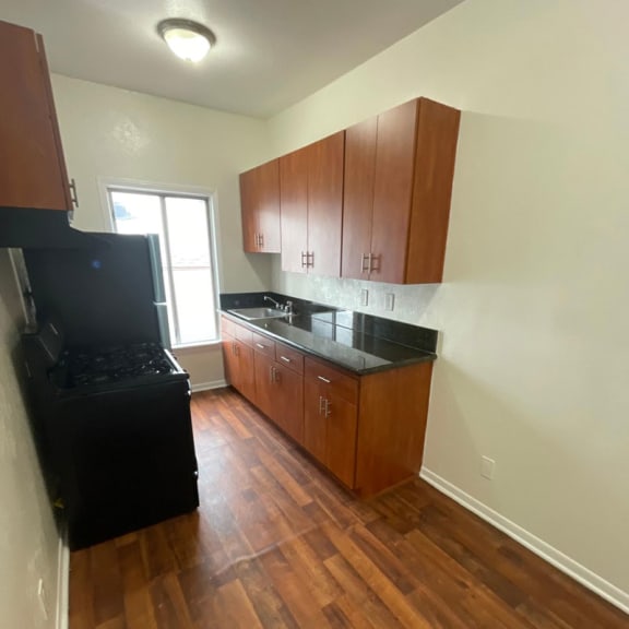 a kitchen with wooden cabinets and a black stove top oven
