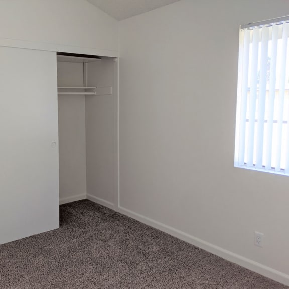 a small bedroom with a closet and a window