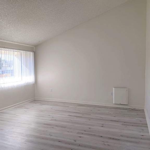 a bedroom with white walls and a large window