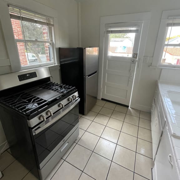 a kitchen with a stove a refrigerator and a sink