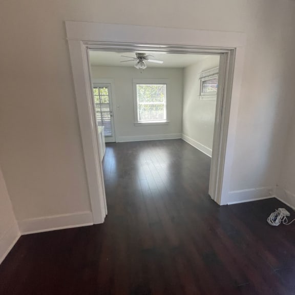 an empty room with a ceiling fan and a window