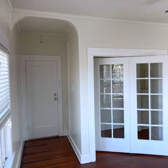 A white door with a window in the middle of a room.