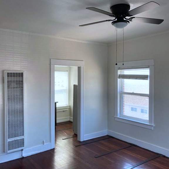 A room with a ceiling fan and a window.