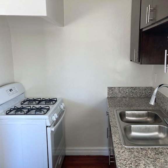A white stove and sink in a small kitchen.