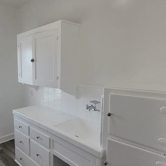 A white bathroom with a sink and a cabinet.