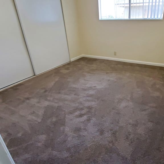 a room with a carpeted floor and a window