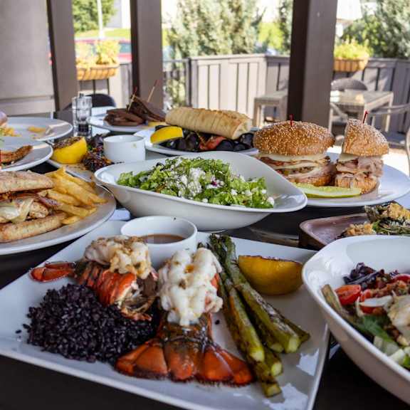 A table full of food including sandwiches, salads, and seafood.
