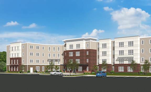 A large, modern apartment complex with multiple buildings and cars parked in front.