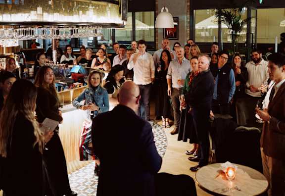 A group of people are gathered in a room for a meeting.