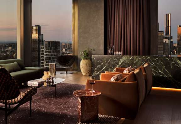 A modern living room with a view of the city skyline at dusk.