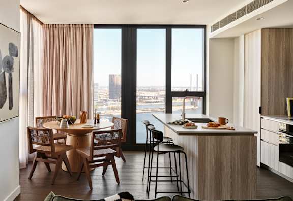 A modern living room with a view of the city skyline at dusk.