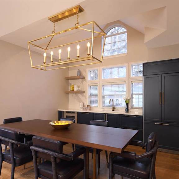 A dining room with a wooden table and black chairs.