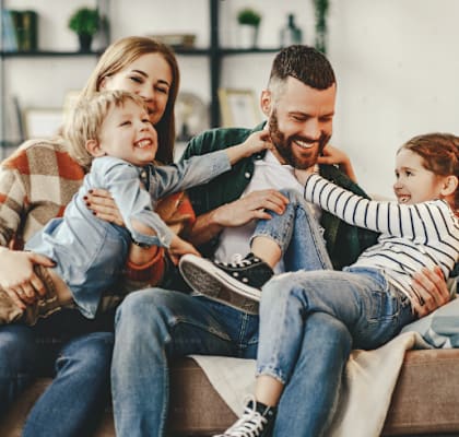 a family sitting on a couch with two children