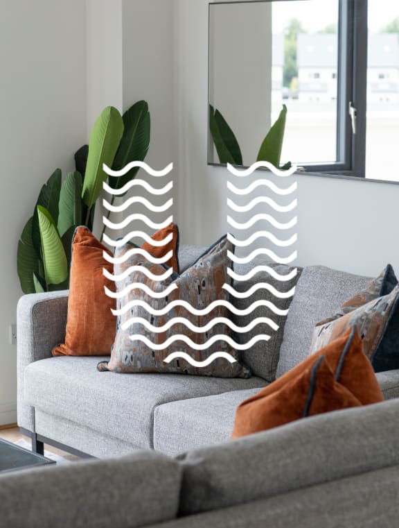 a living room with a couch and pillows with a wave shaped pillow case on