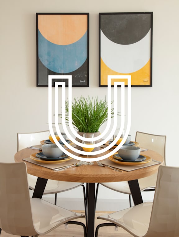 a dining room with a table and chairs and paintings on the wall