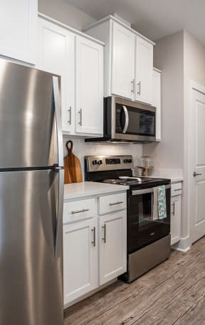 a kitchen with stainless steel appliances and white cabinets