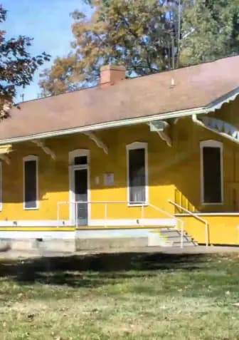 a yellow house with a red roof is shown in a yard