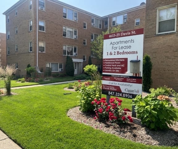 an apartment building with red balconies and a green yard