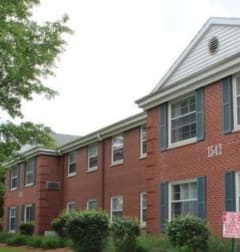 a red brick building with a pink sign in front of it