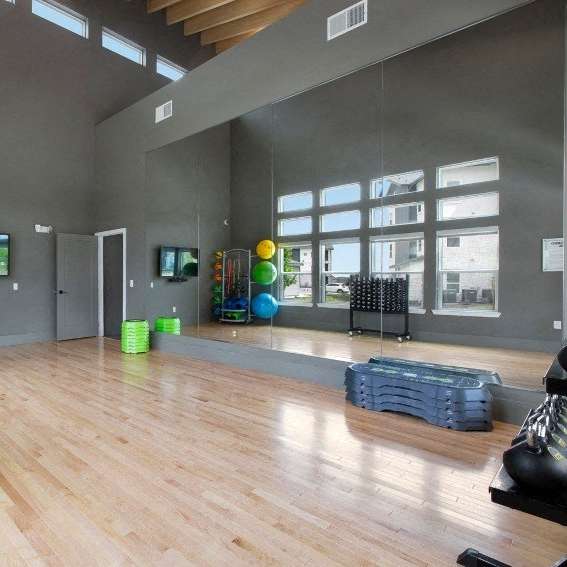 A gym with exercise equipment and a TV.