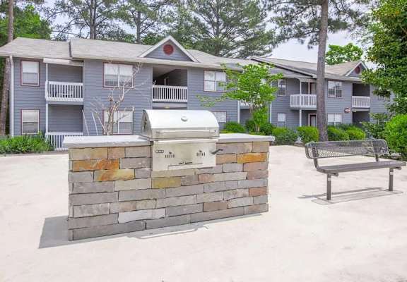 a picnic table and a grill in front of an apartment building