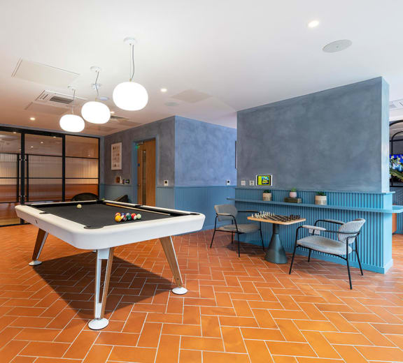 a game room with a pool table and a bar