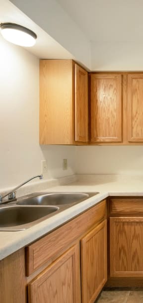A kitchen with wooden cabinets and a sink. at Northeast Villas, Minnesota, 55421