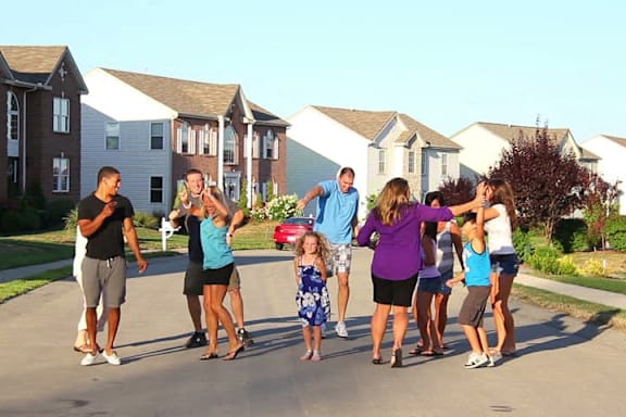 A group of people are standing in the middle of a street.