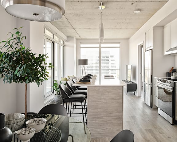 A living room with a green chair and a white sofa. at Le Columbia Apartments , Quebec, J8Y 0A8