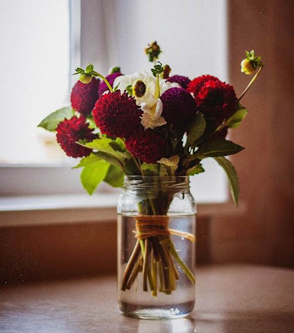 a vase filled with red and white flowers on a table