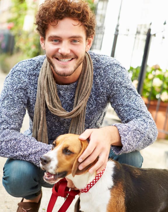 a man kneeling down next to a dog at Proximity at ODU, Norfolk, Virginia