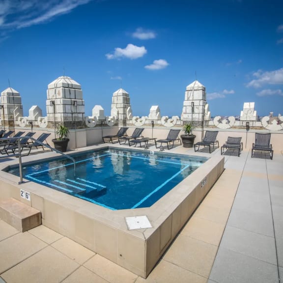 a swimming pool on the rooftop of a building with a city in the background