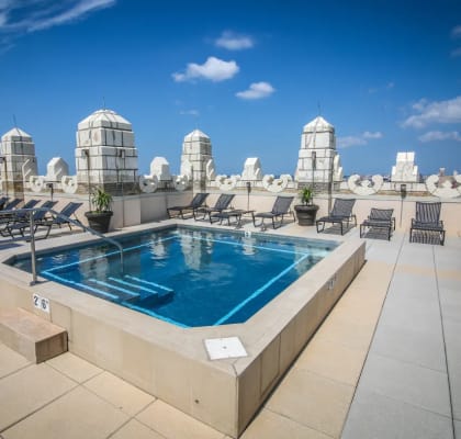 a swimming pool on the rooftop of a building with a city in the background