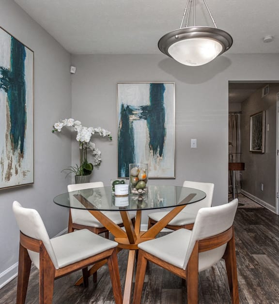 a dining room with a glass table and chairs