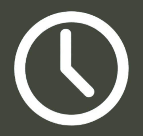 a white clock icon in a circle on a green