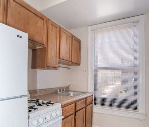 a kitchen with white appliances and wooden cabinets