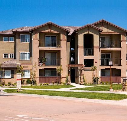 an apartment building with a sidewalk in front of it