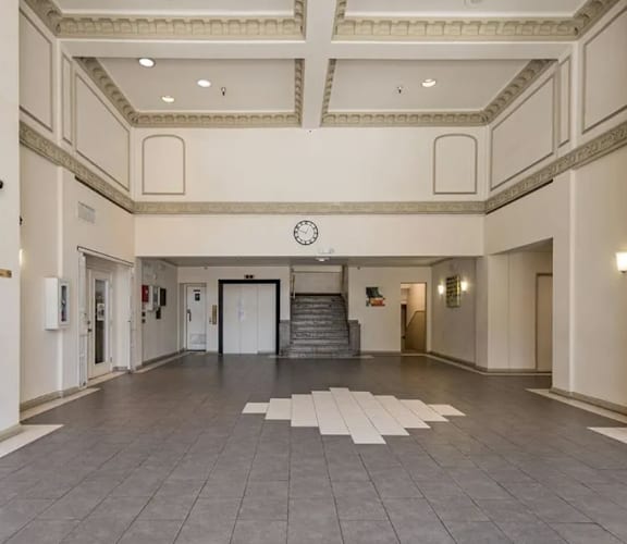 a large room with a clock on the wall and a staircase