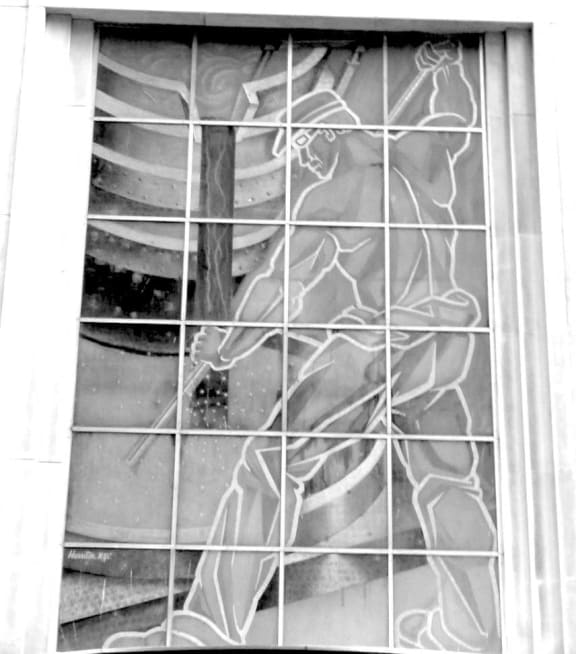 a window of a church with a woman reflected in it