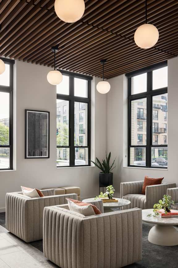 A living room with a wooden ceiling and striped couches.