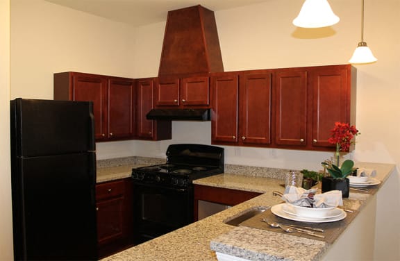 Kitchen at Arden Woods with black appliances and granite counter tops.