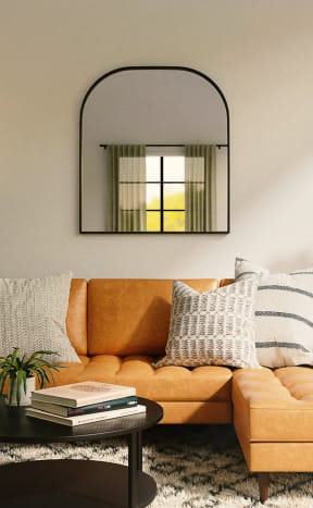 Model Living Room with Brown Leather Couch and Mirror on Wall