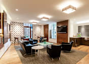 Thumbnail 1 of 23 - A modern living room with a glass table and black chairs.