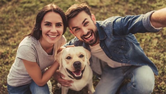 Background Image representing happy couple with dog at Tysons Glen Apartments and Townhomes, Falls Church, Virginia