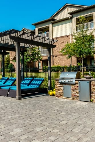 a brick patio with lounge chairs and barbecue grills at Echo at Lake Norman, Mooresville, NC