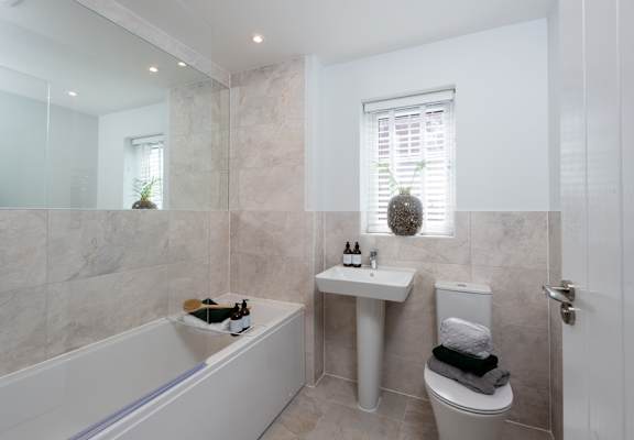A bathroom with a tub, toilet, and sink.