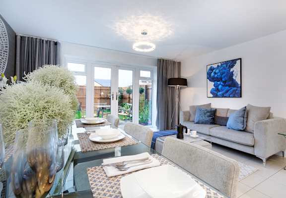 a living room with a glass coffee table and a couch