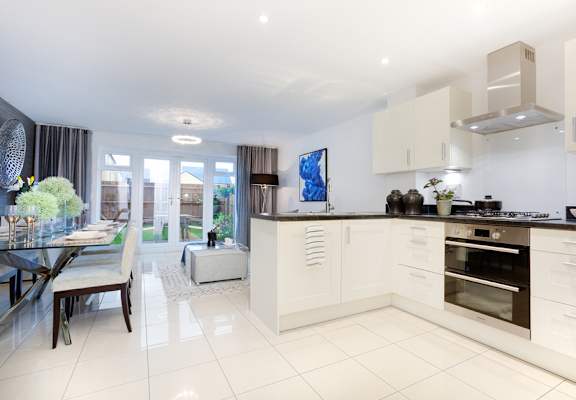 a white kitchen with a dining area and a living room